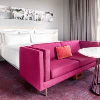 A bed, couch and table in a 21C Museum Hotel Room