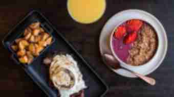 A breakfast of eggs, potatoes, yogurt and orange juice